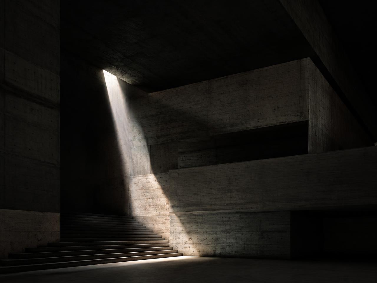 Brutalist concrete interior with a single beam of daylight falling across a staircase