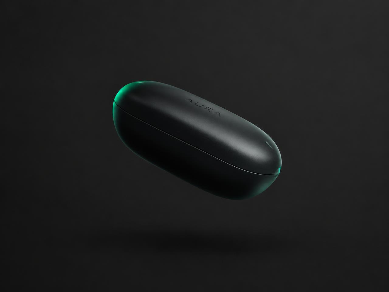 Matte black capsule-shaped product floating against graphite with a green rim light